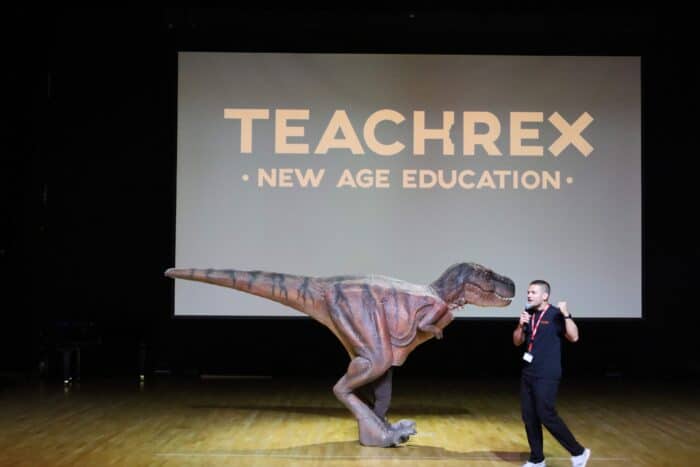 Sam on stage with Jam the T-Rex during a workshop